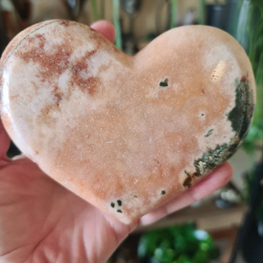 pink heart crystal held by a hand