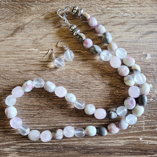 Beaded necklace and earrings on a wooden surface
