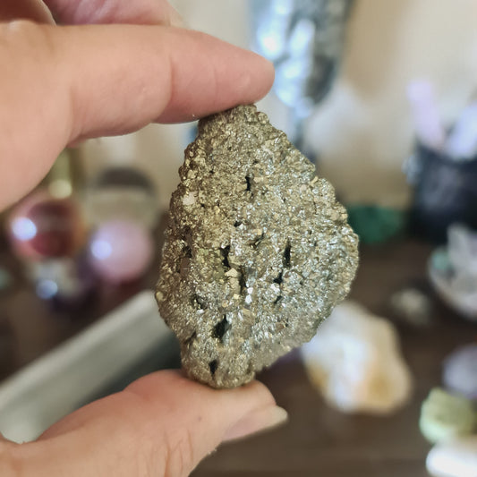 A person holding a large, polished pyrite crystal chunk.
