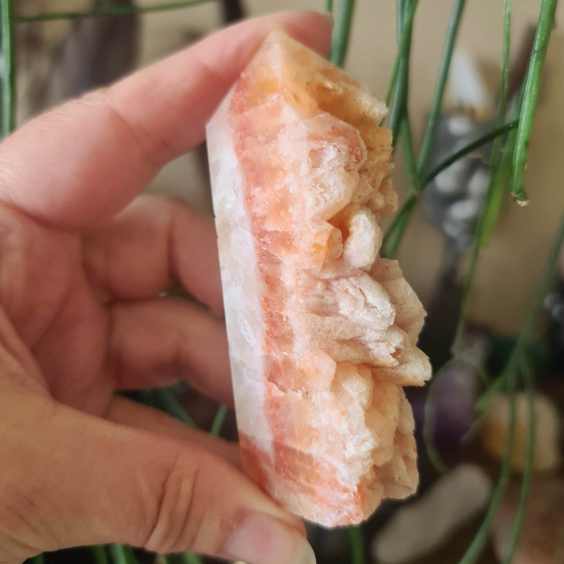 pink and white raw crystal in a hand