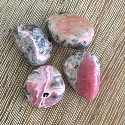 Four polished gemstones on a wooden surface