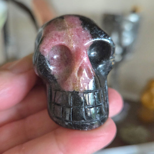 Crystal skull held in a hand with a blurred background