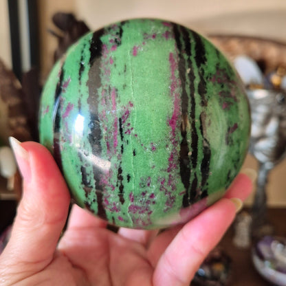 green crystal ball with pink and black striping