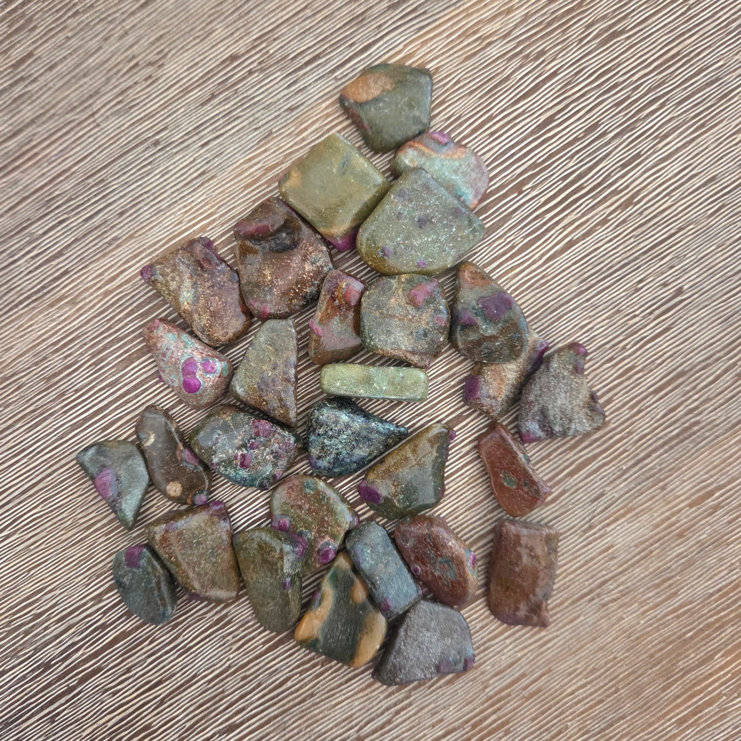 Collection of small, multicolored stones on a wooden surface