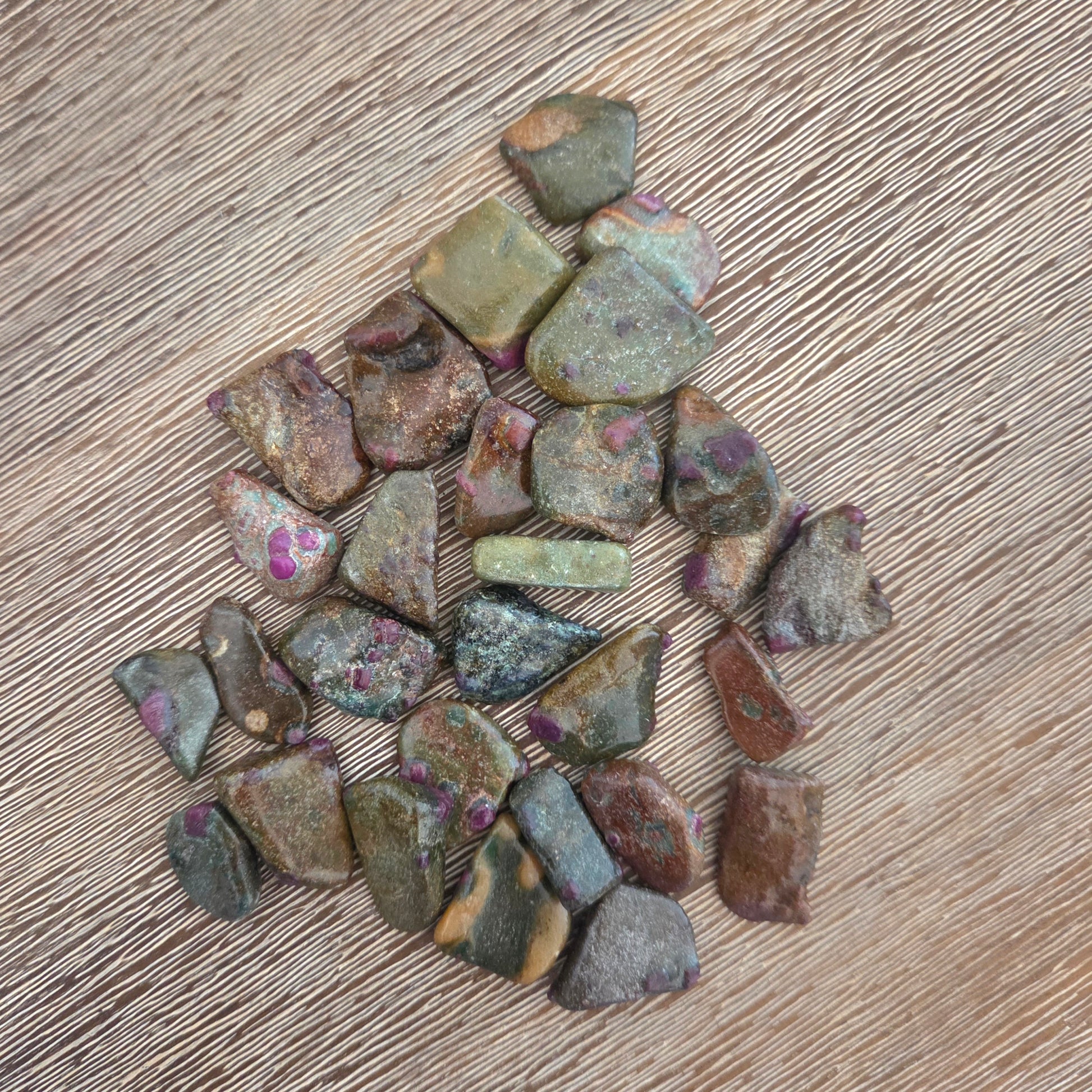 Collection of small, multicolored stones on a wooden surface
