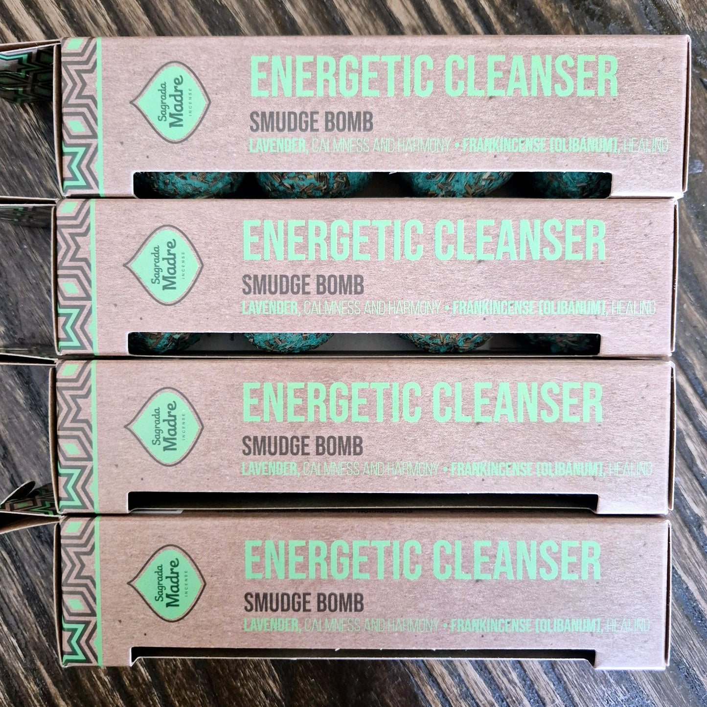Packaging for 'Energetic Cleanser Sage Smudge Bomb', featuring green text and design elements on a cardboard box with a visible green and white design on the box lid.