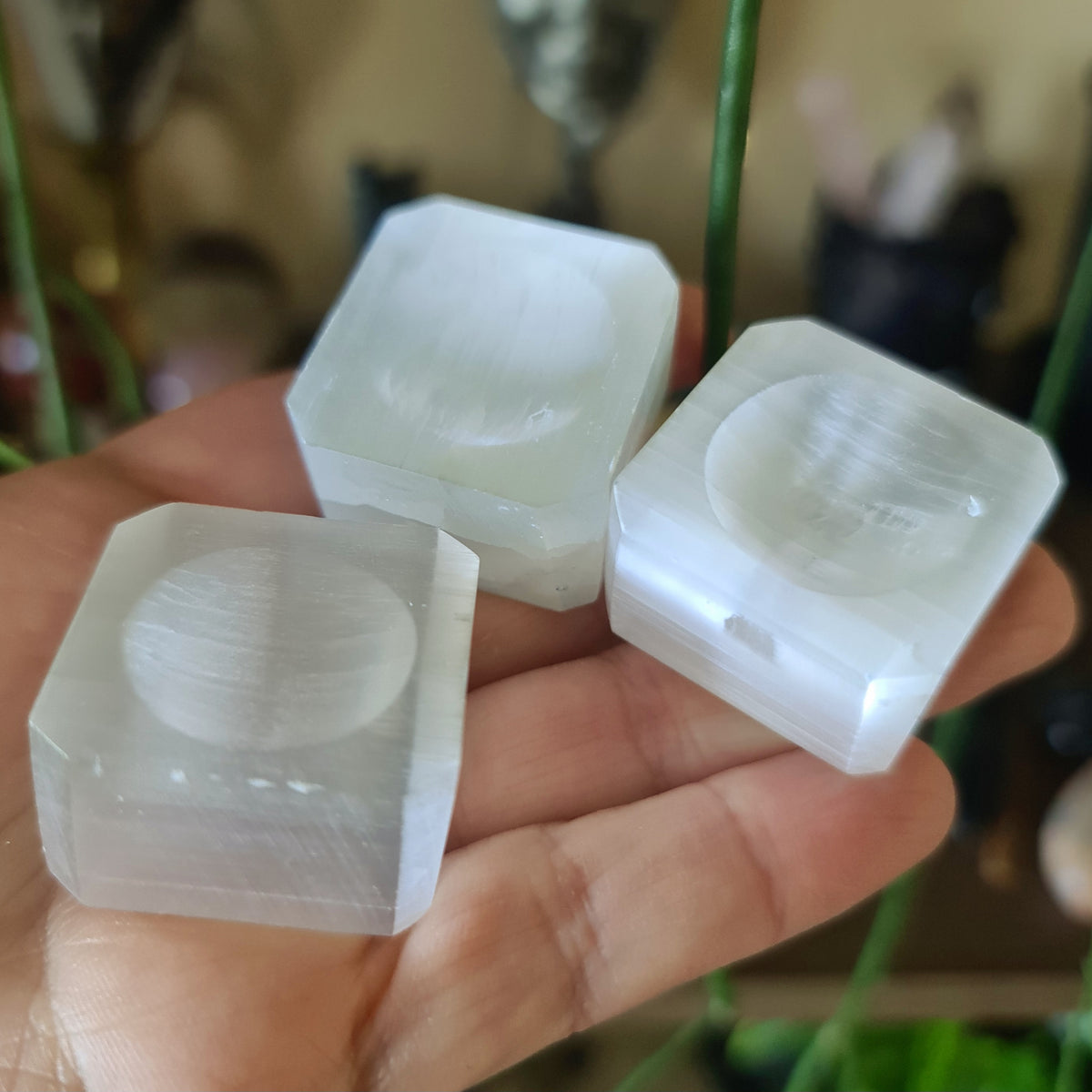 white crystal bases for spheres displayed on a hand