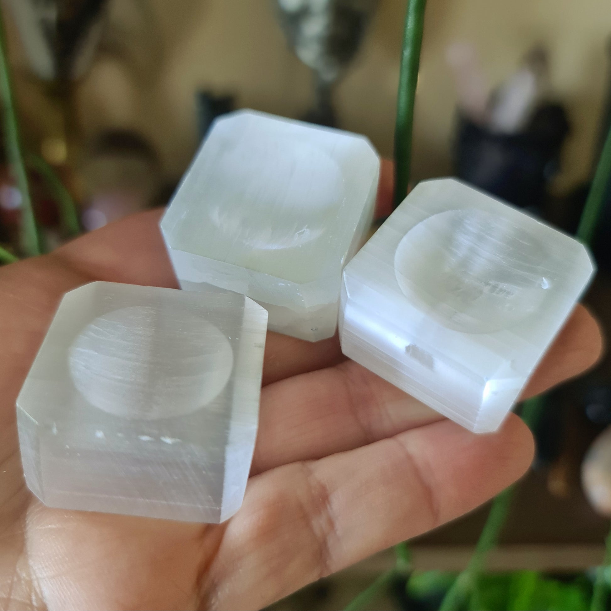 white crystal bases for spheres displayed on a hand