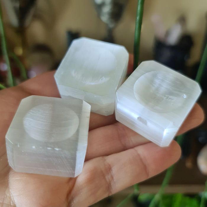 white crystal bases for spheres displayed on a hand