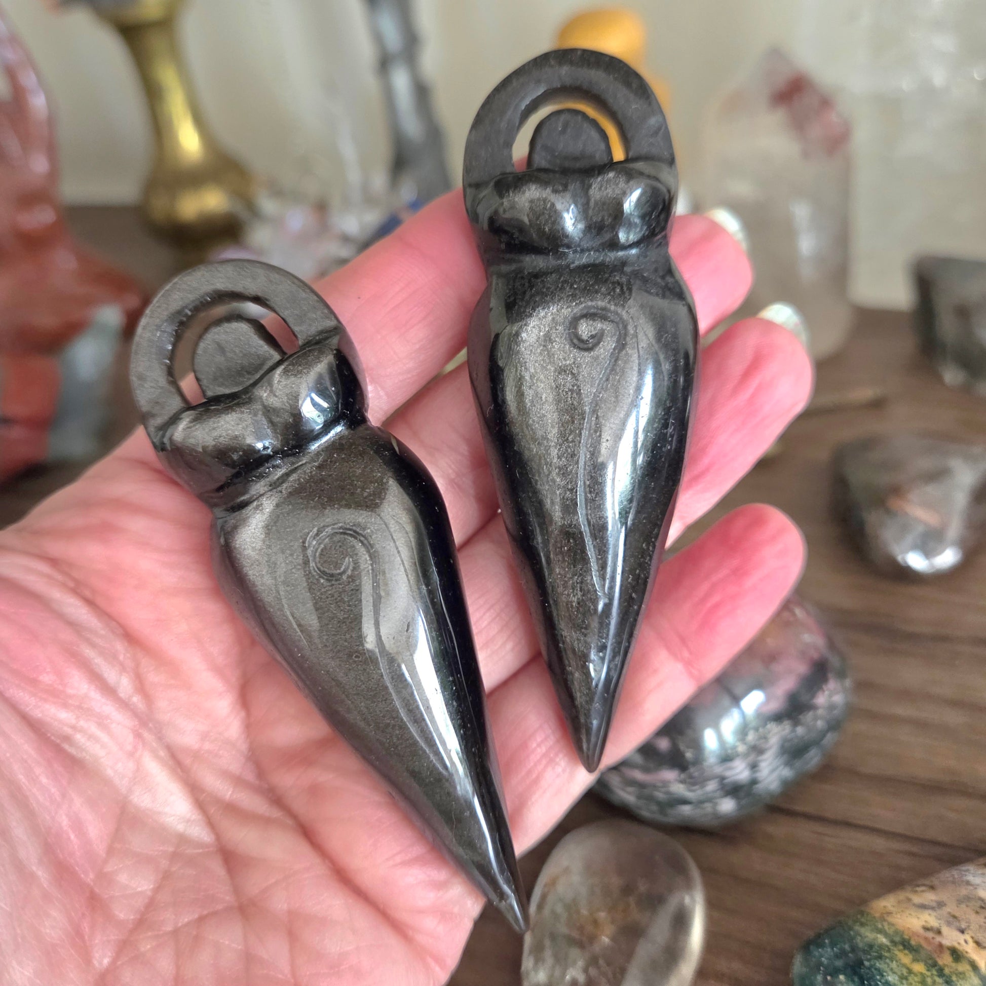 Two decorative stone objects held in a hand with a blurred background