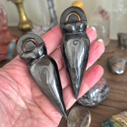Two decorative stone objects held in a hand with a blurred background