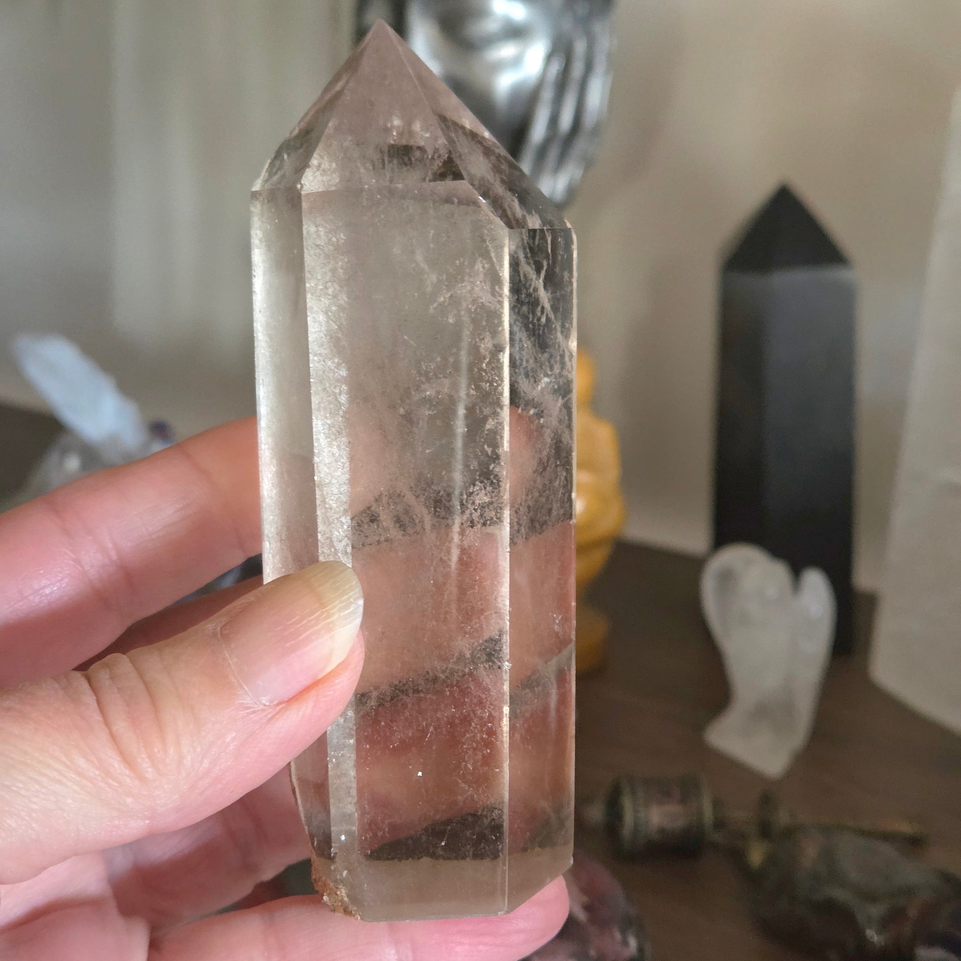 Clear crystal tower held by a hand with a blurred background