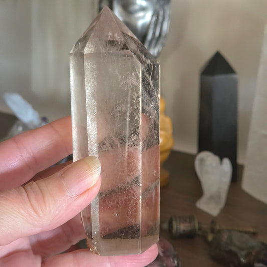 Clear crystal tower held by a hand with a blurred background
