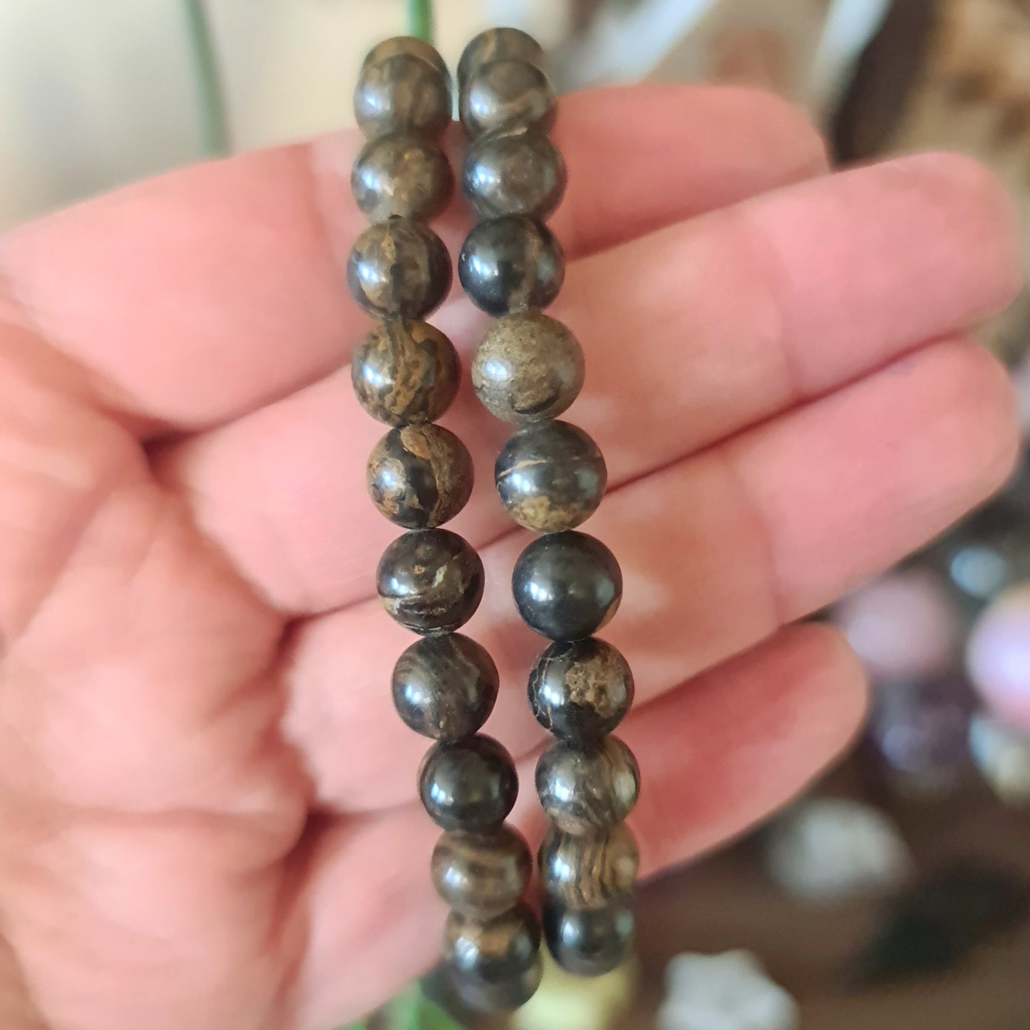 brown crystal bracelet held in a hand