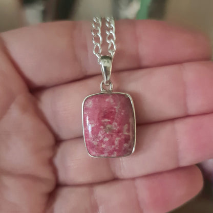 A pink Thulite Pendant set in a silver frame with a snake chain.
