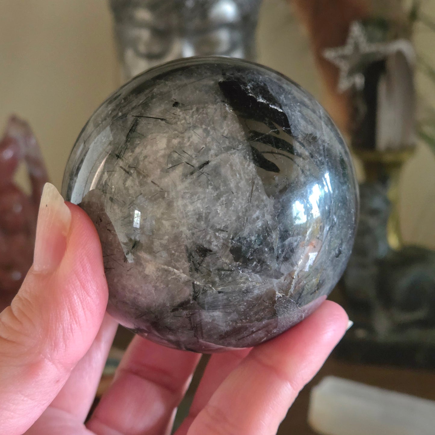 Hand holding a rough-textured crystal ball with a blurred background