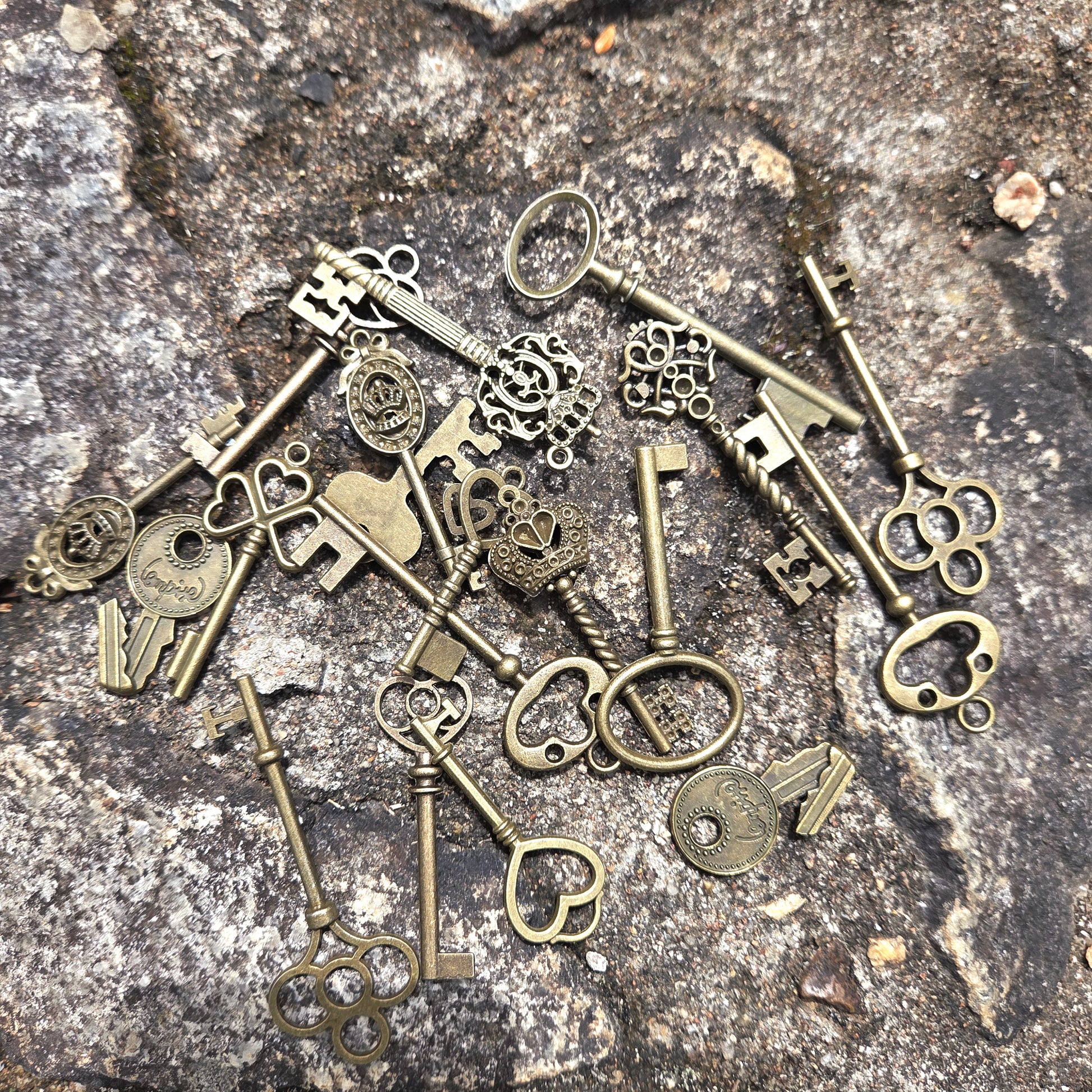 Collection of vintage-style bronze keys on a stone surface