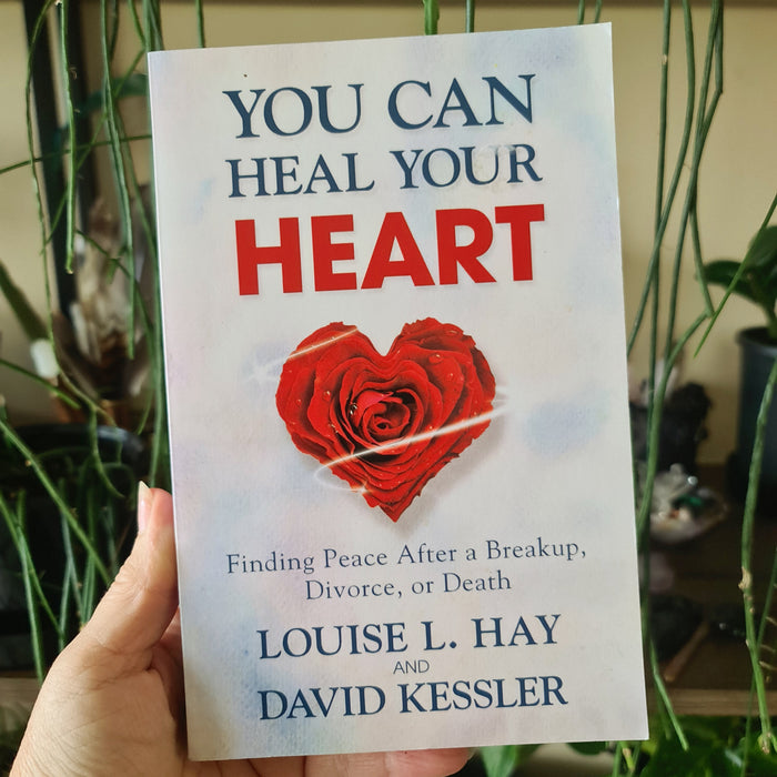 A book titled 'You Can Heal Your Heart' by Louise L. Hay and David Kessler, featuring a red rose on the cover.