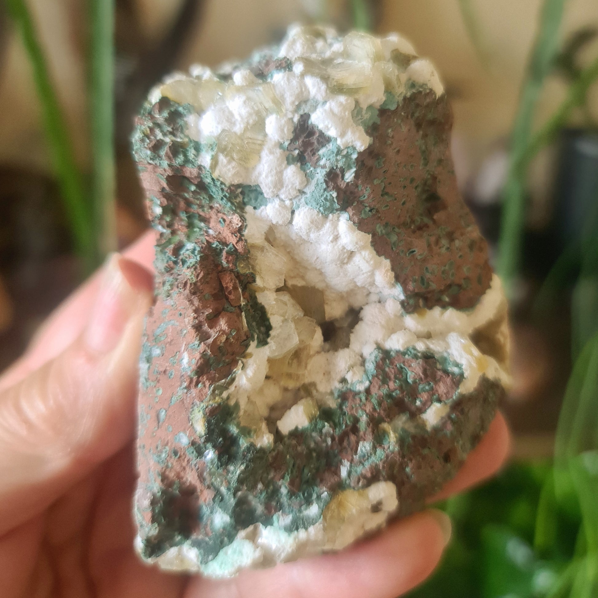 green and white crystal on a rock
