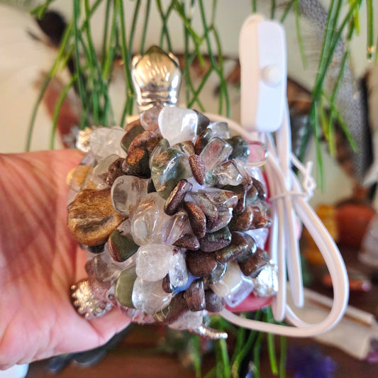 Decorative stone ball with a white cord against a blurred indoor background