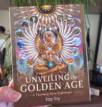 Book titled 'Unveiling the Golden Age' by Izzy Ivy held in a hand with a blurred background