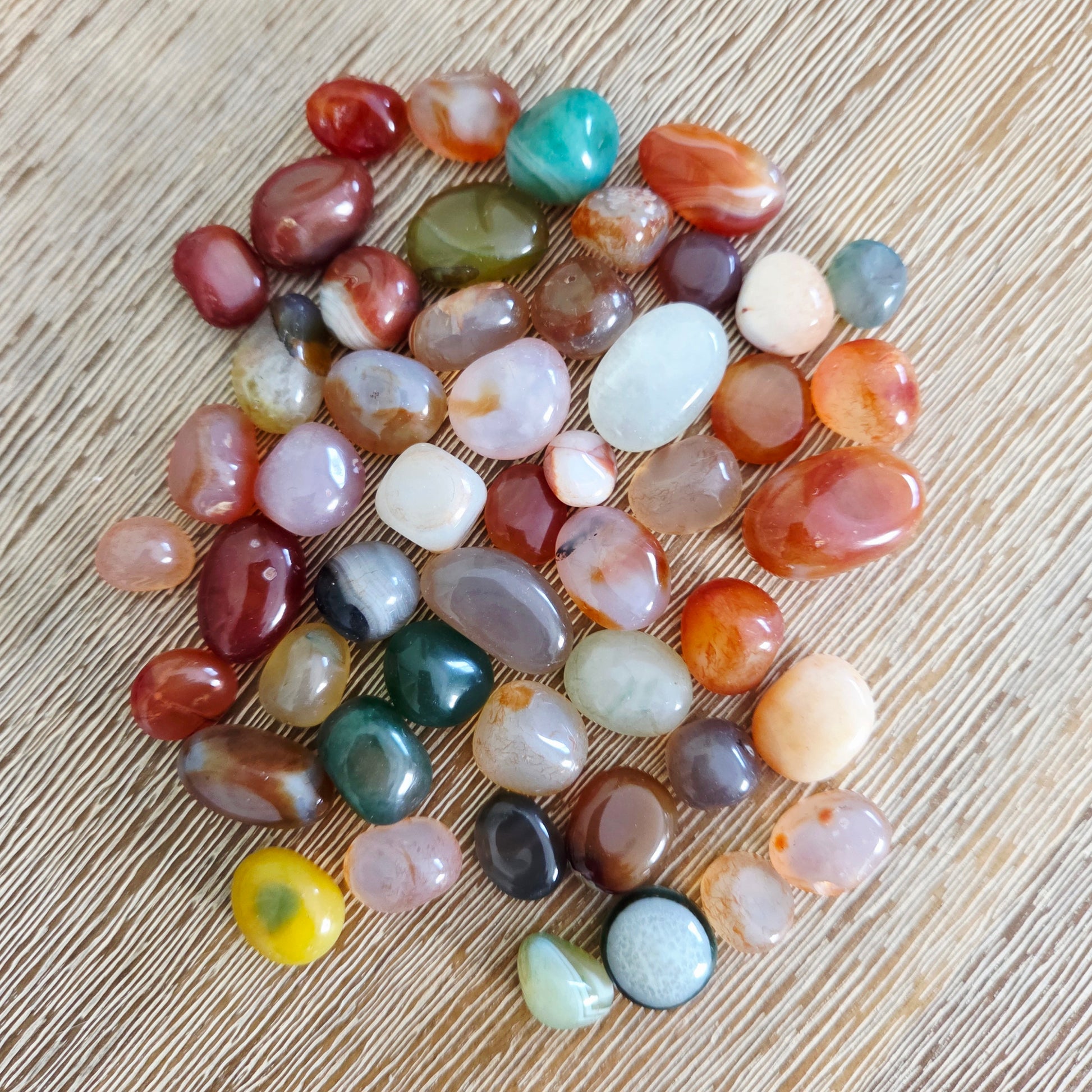 Assorted multicolored stones on a wooden surface