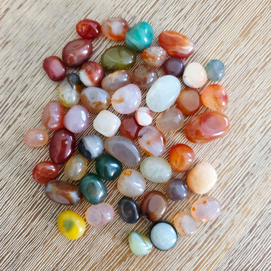 Assorted multicolored stones on a wooden surface