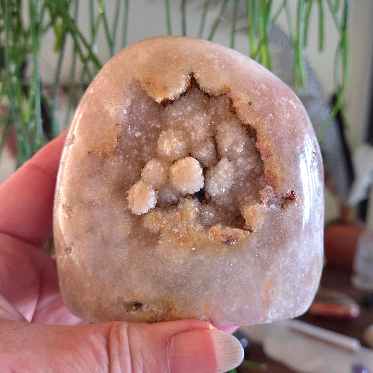 Geode held in a hand with a blurred indoor background
