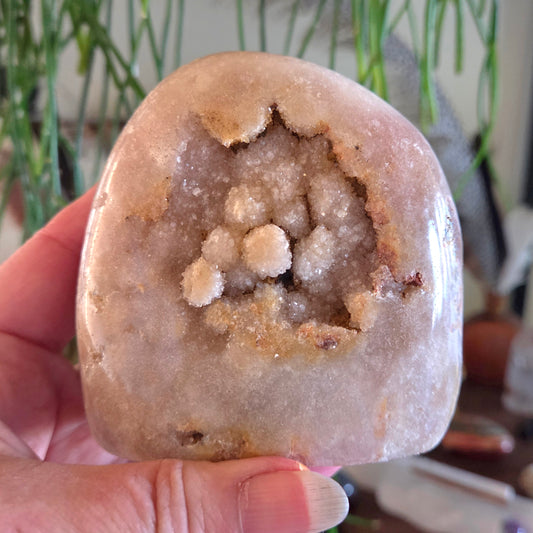 Geode held in a hand with a blurred indoor background