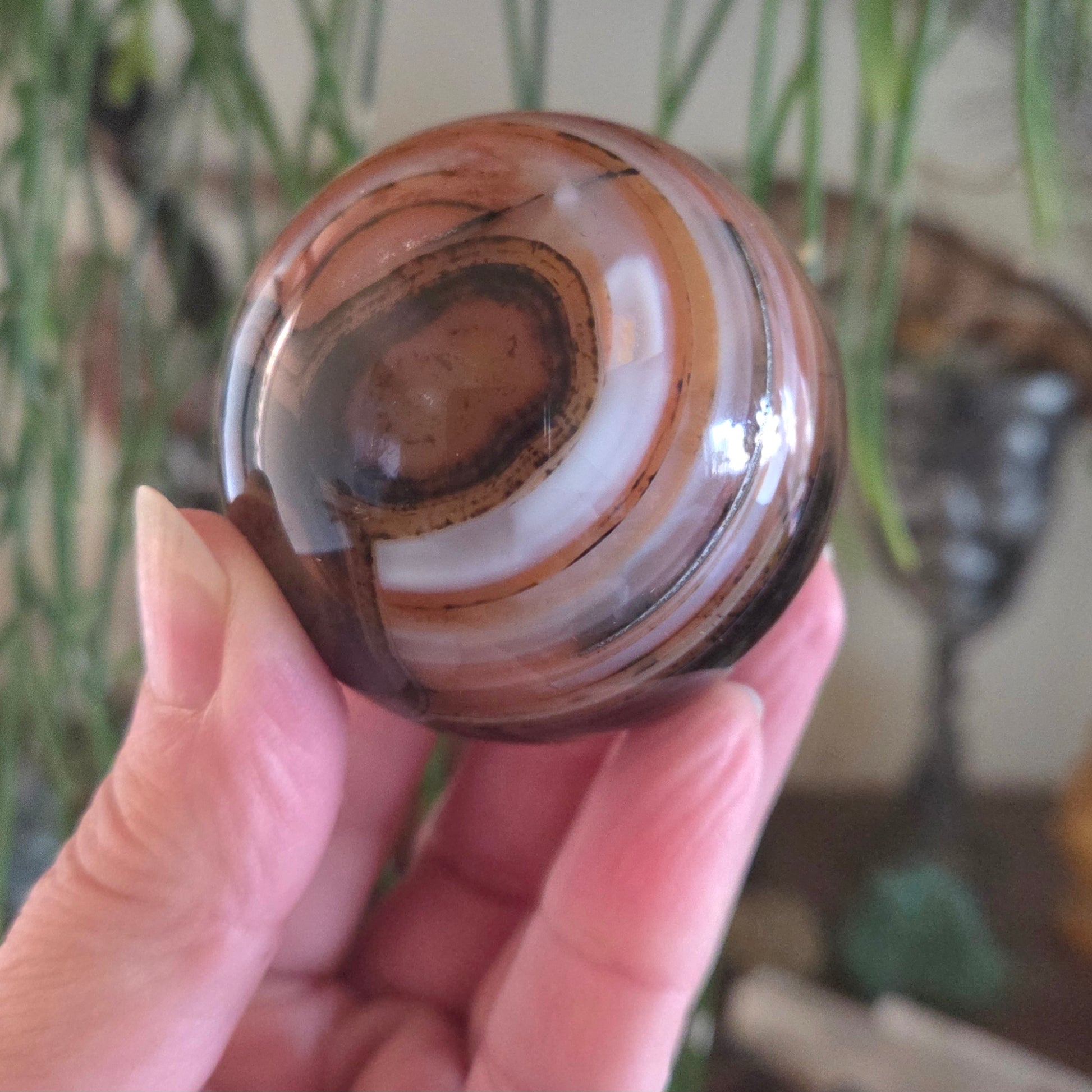 Hand holding a marbled stone with a blurred background