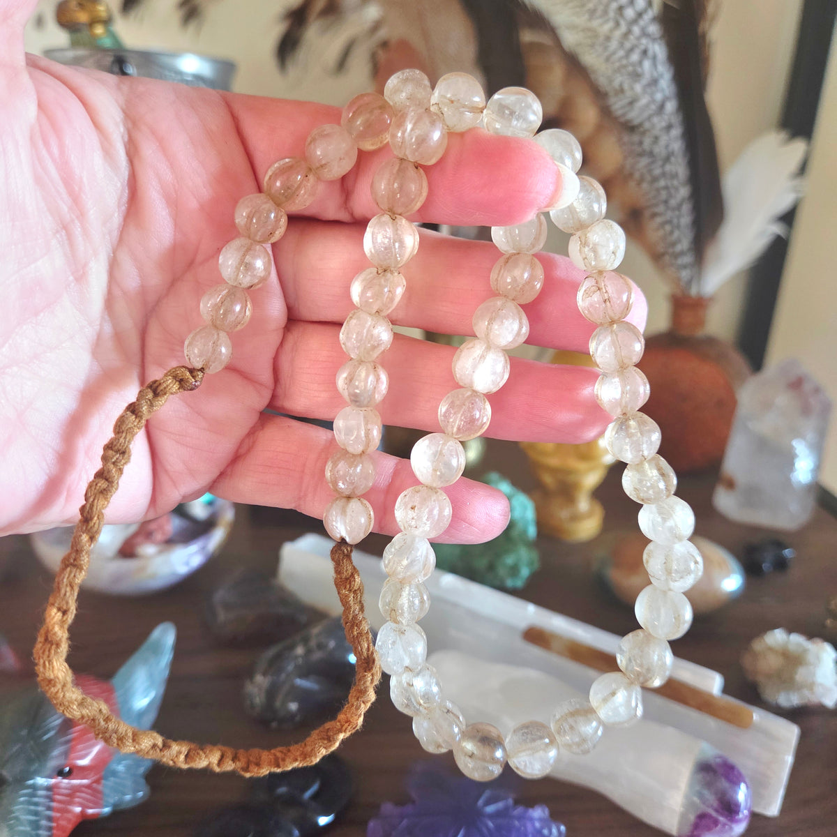 Hand holding necklace with a blurred background