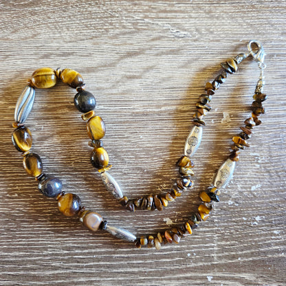 Necklace with tiger eye and silver beads on a wooden surface