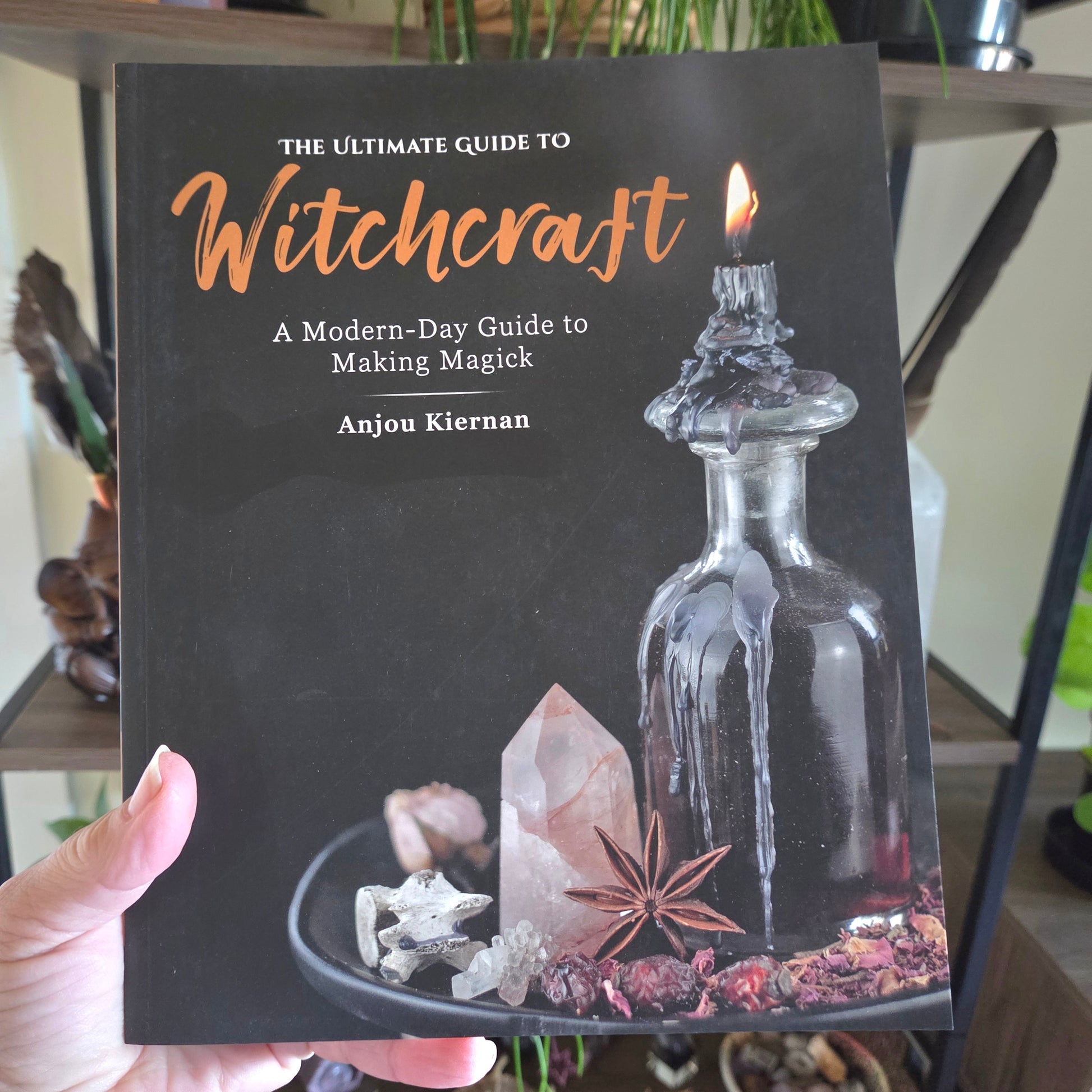 Book titled 'The Ultimate Guide to Witchcraft' held by a person
