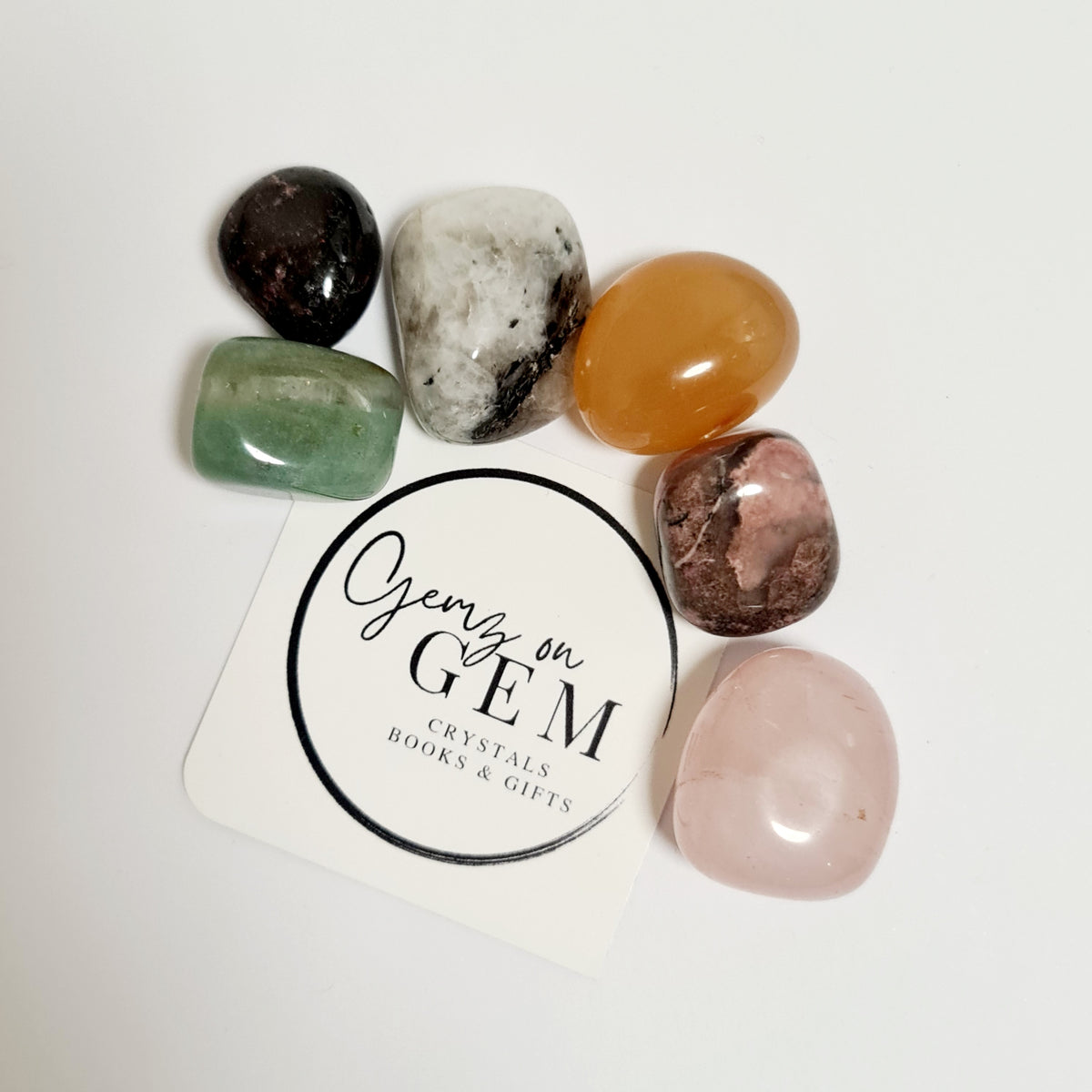 An assortment of polished and unpolished crystals displayed on a card with 'Gemz on Gem' branding.